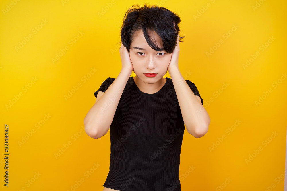 Woman plugging ears with hands does not wanting to listen hard rock or loud music. European Young female ignoring noise or din covering her ears with hands avoiding loud sounds at street. Woman plugging ears with hands does not wanting to listen hard rock or loud music. European Young female ignoring noise or din covering her ears with hands avoiding loud sounds at street.