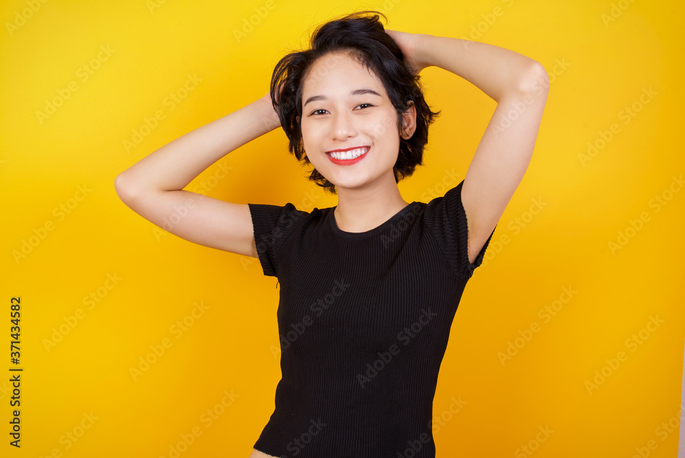 Confidence and coquettish concept. Portrait of charming young business girl, smiling broadly with self-assured expression while holding hands over her head. Standing against background.
