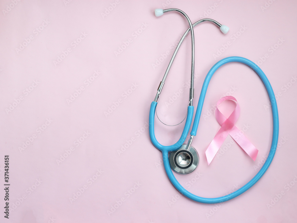 Fototapeta premium Breast cancer awareness pink ribbon with doctor stethoscope on pink background, october symbol, healthcare and medicine concept ....
