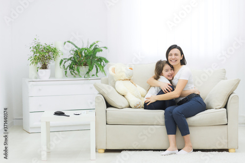 Family portrait of small daughter hugging her mother.