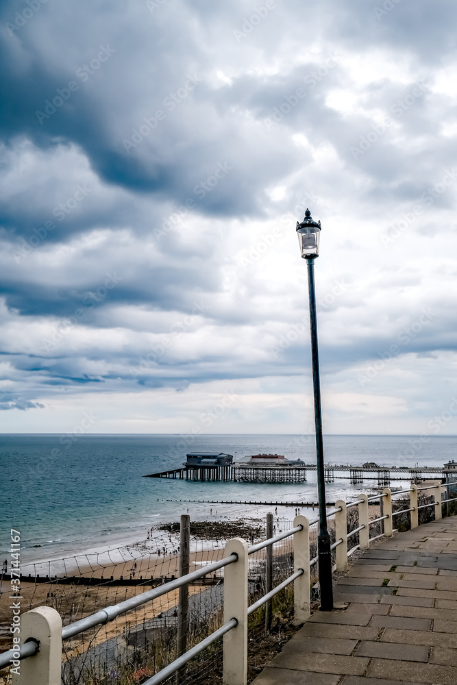 A lamp post on the coastal path along Cromer on the North Norfolk coast. In the distance is the Vitcorian pier.