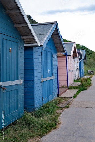 A row of traditional wooden beach huts lined along the promenade in the seaside town fo Cromer on the North Norfolk coast © yackers1