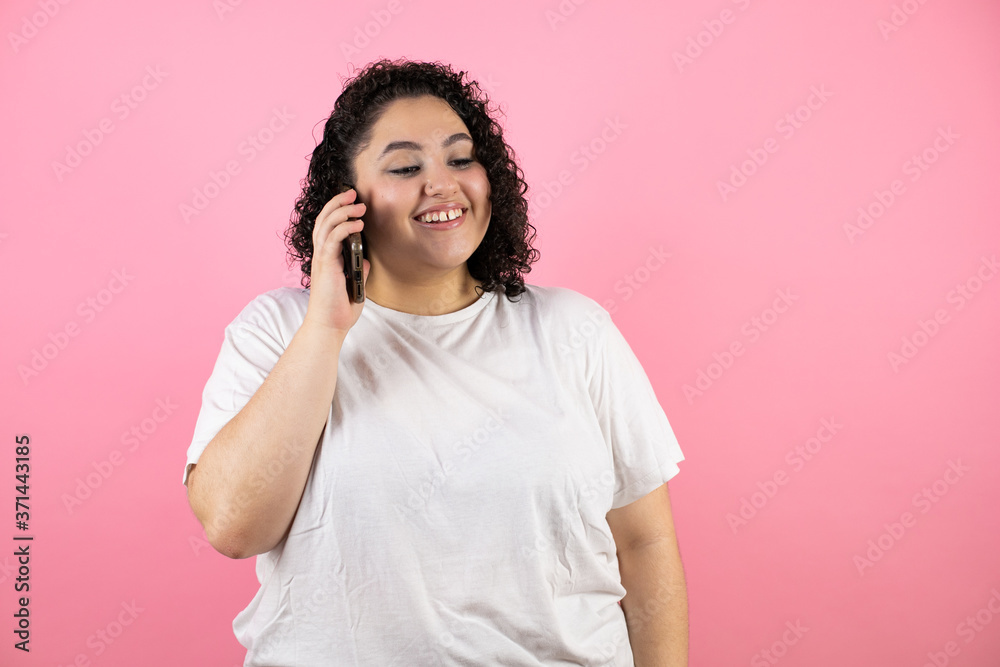 Young beautiful woman talking on the phone, smiling on pink background. Young beautiful woman talking on the phone, smiling on pink background.