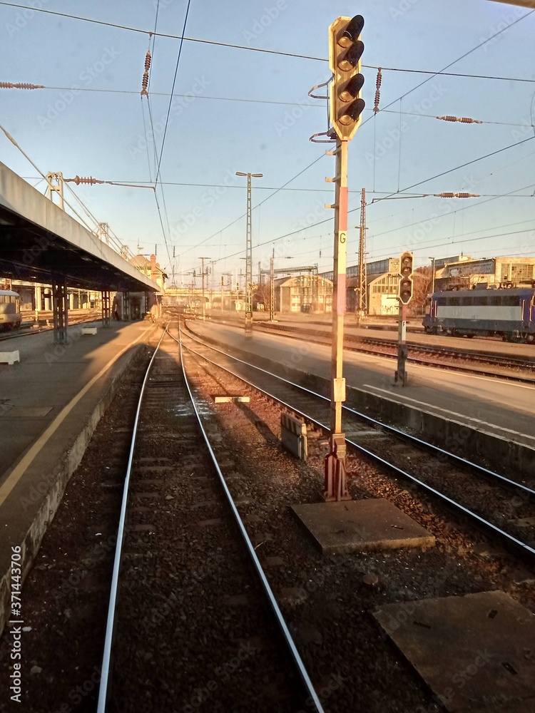 A train traveling down train tracks near a station