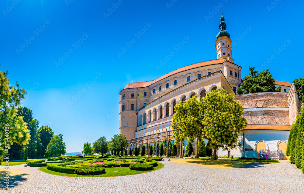 The Mikulov castle, Czech republic. Famous medieval castle on top of hill. Beautiful ornament garden with flowers, trees and green grass. Summer weather and blue sky. Beautiful wine region near Palava
