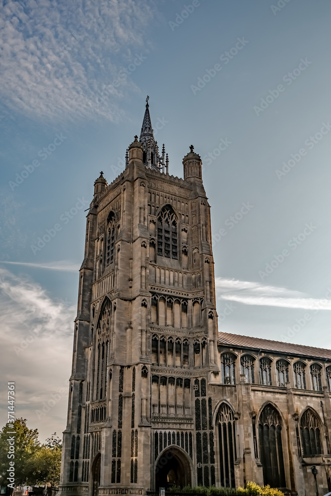 A view loking up at an Anglican church tower agianst a blue sky