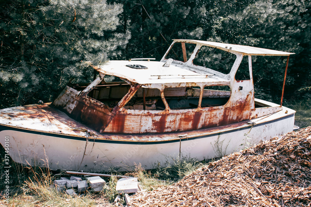 
The yacht is old, abandoned in the forest, very rusty.