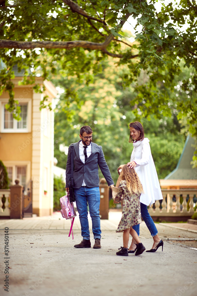 Obraz premium Mom and dad walking with daughter