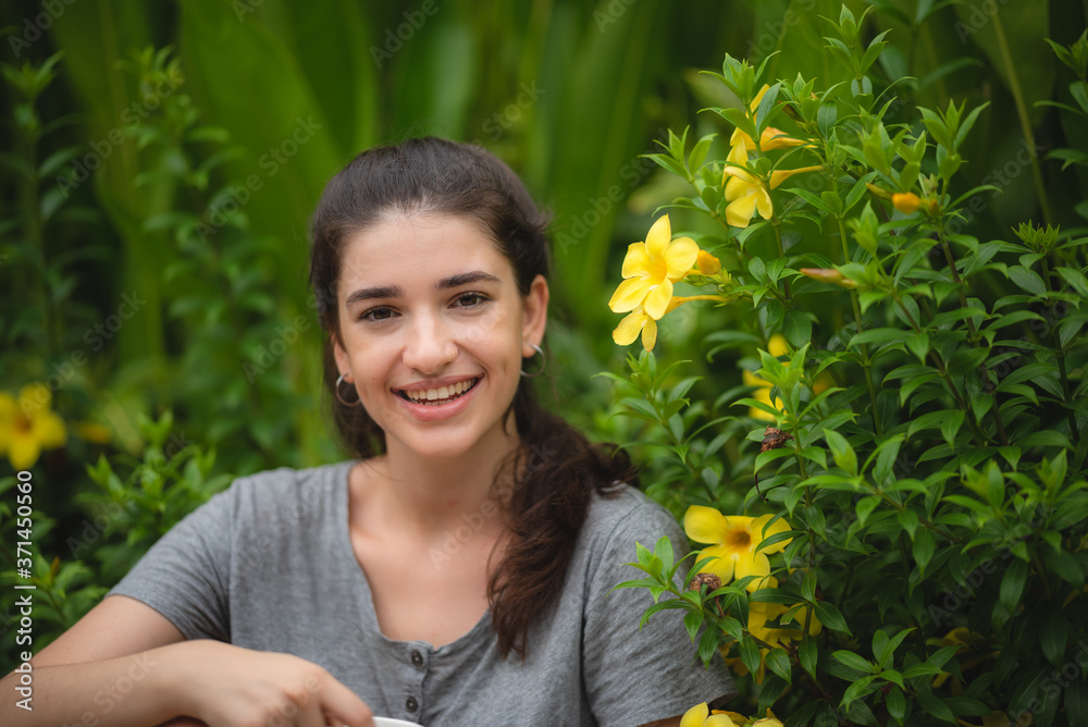 Beautiful young woman smelling yellow flower in the park, happy morning Beautiful young woman smelling yellow flower in the park, happy morning