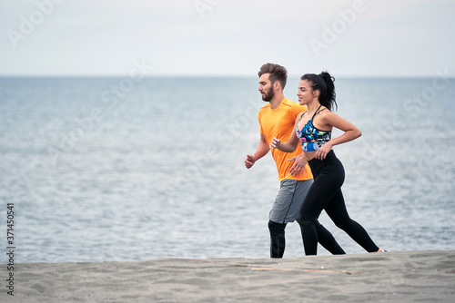 Male and female running on the beach; Healthy lifestyle concept
