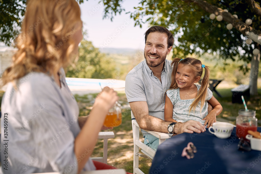 Father with  daughter sitting at table outdoor and  enjoying together.