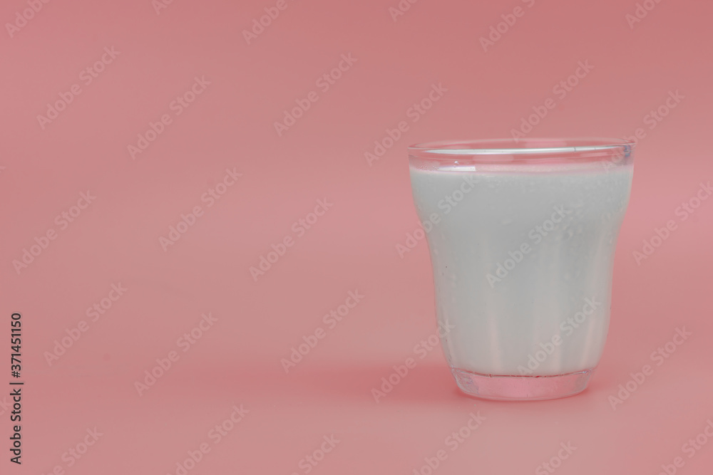 Fresh Milk in glass with copy space on pink background Fresh Milk in glass with copy space on pink background