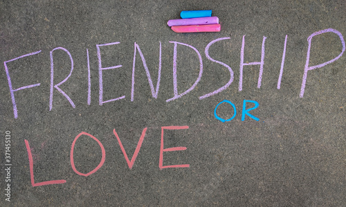 The inscription text on the grey board, FRIENDSHIP OR LOVE. Using color chalk pieces.