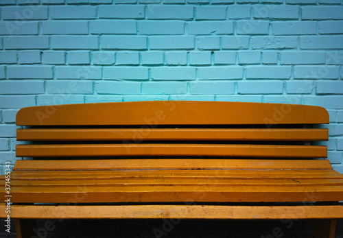Orange bench with aqua cyan bricked wall