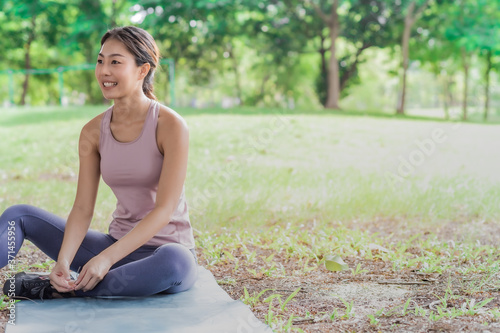 Young woman listening to music before running and excercise in the park.