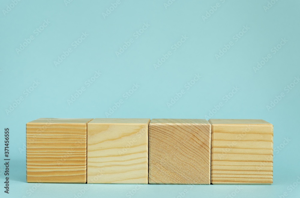 Construction of wooden cubes on blue background with copy space. Mockup composition for design