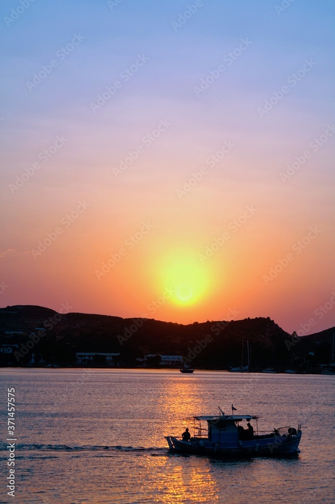 Greece, Patmos island, sun rising, sun's first appearance in the morning above Patmos island.