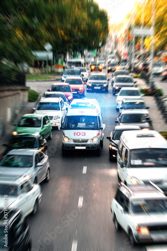 an ambulance rushes to a call on the highway through a traffic jam