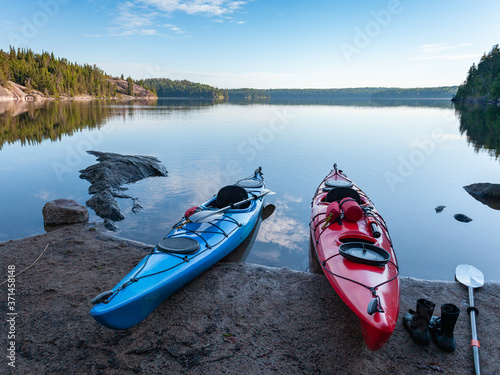 A red and blue kayak parked at the shore of Tulabi lake in Nopiming Provincial Park in the early morning