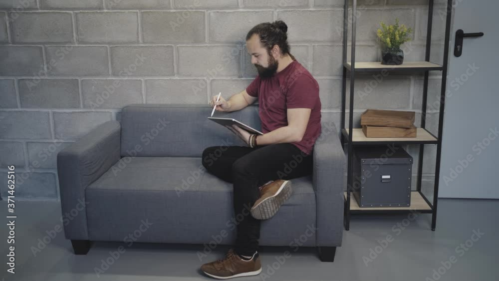 Young man using tablet in loft workspace Young man using tablet in loft workspace