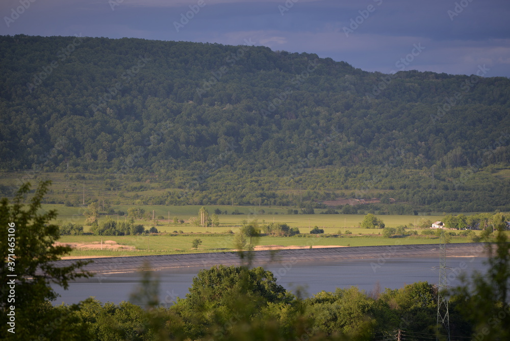 spring landscape with forest near the lake at sunset. cultivated fields spring landscape with forest near the lake at sunset. cultivated fields