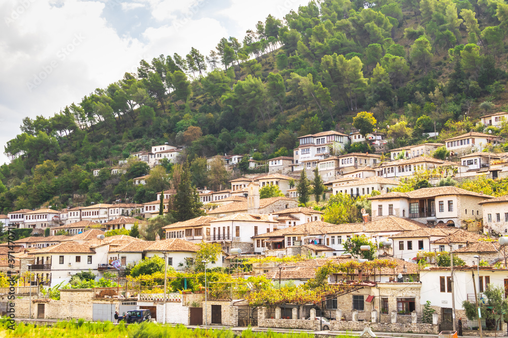 Traditional houses n Berat old town with trees and locals around. historical places in Albania.