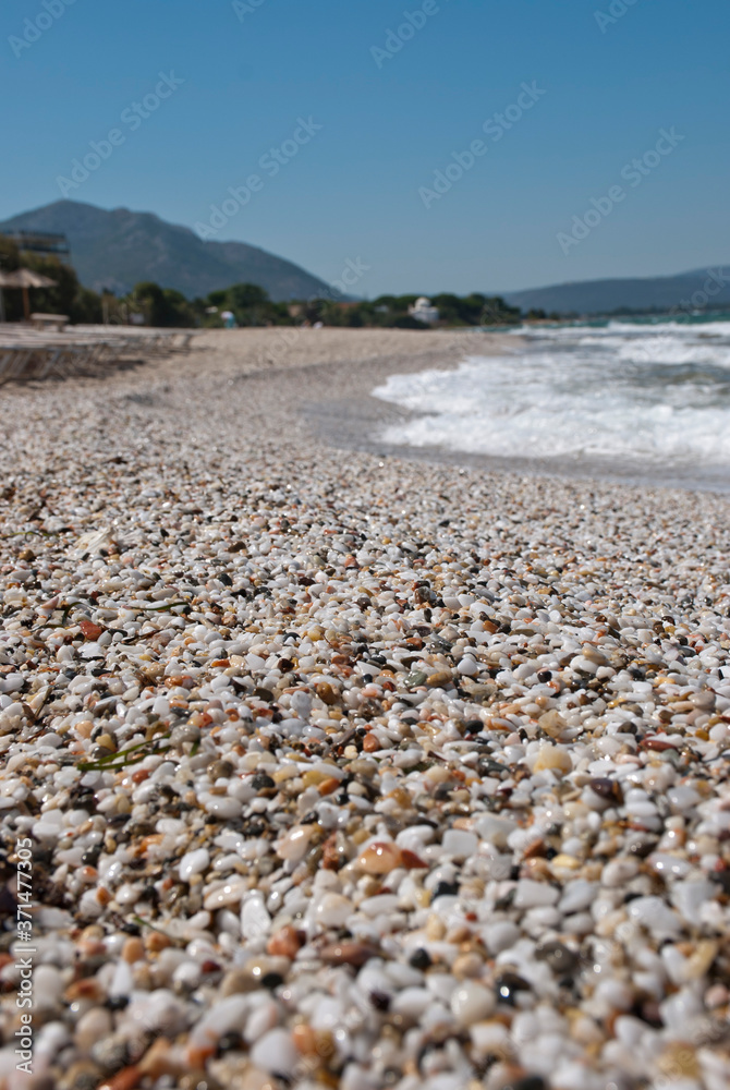 Athens, Greece, August 2020: Beautiful pebbled beach and stormy sea waters