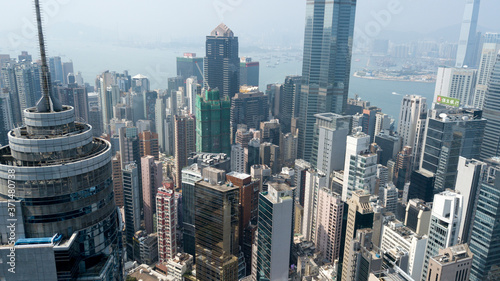 Hong Kong / March 28 2018: Aerial view of Hong Kong city. Skyscrapers, office glass buildings business centers near Victoria harbour bay concrete jungle megalopolis cityscape city life. Sunny blue sky