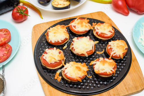 step-by-step recipe for homemade vegan pizza with eggplant for a bite, tomatoes, peppers, mozzarella . hands of a woman preparing a pizza with a view from above . light background.