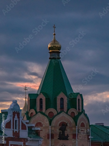 golden dome and cross against the sunset sky. Russia, Yoshkar-Ola, Brugge Embankment