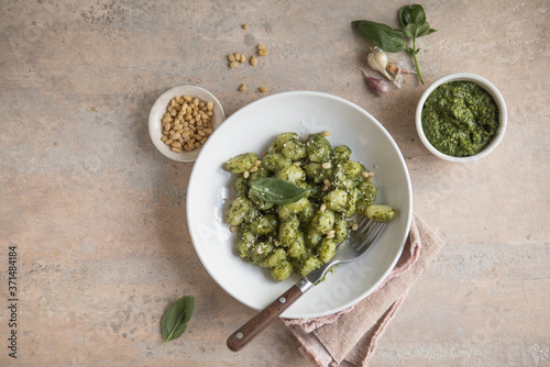 Italian food: homemade gnocchi with pesto sauce Parmesan and basil on concrete  table