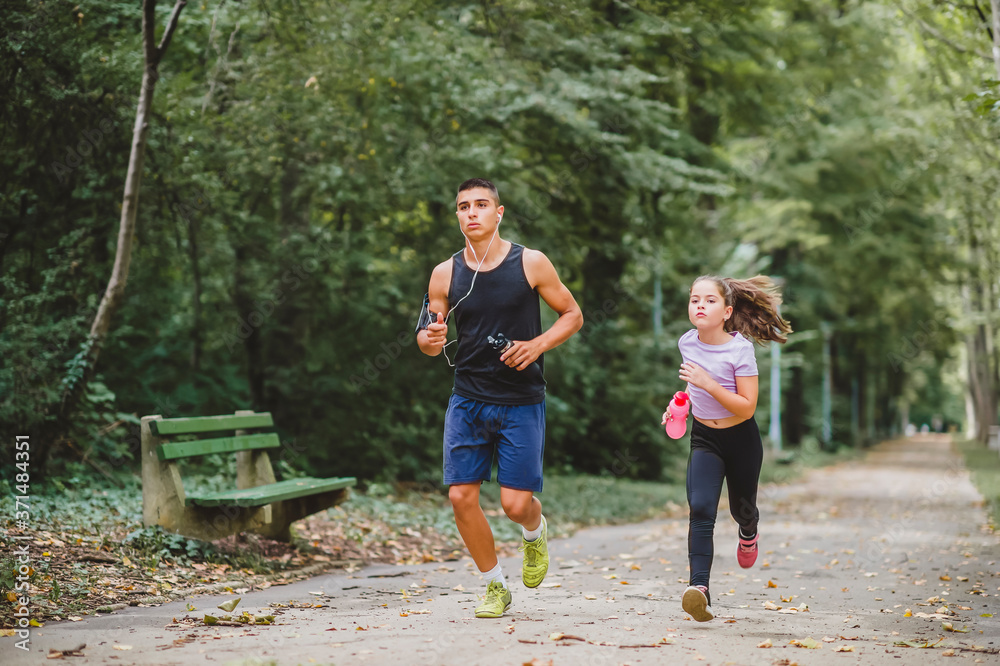 Young sporty man and girl are running in the park Young sporty man and girl are running in the park