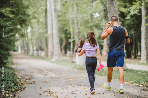 Young sporty man and girl are running in the park