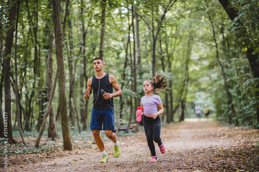 Young sporty man and girl are running in the park Young sporty man and girl are running in the park