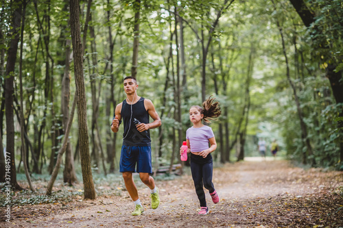 Young sporty man and girl are running in the park