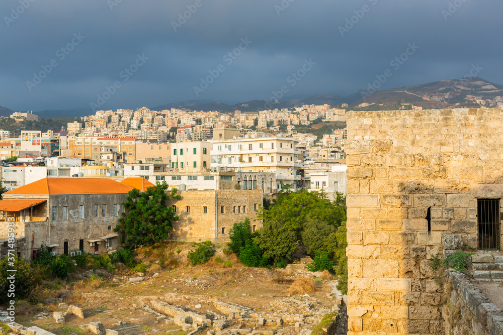 Byblos Crusader Castle, Lebanon. Panoramic view of old stone walls and modern view of the city Jbeil on the hills. Historical and modern parts of the town