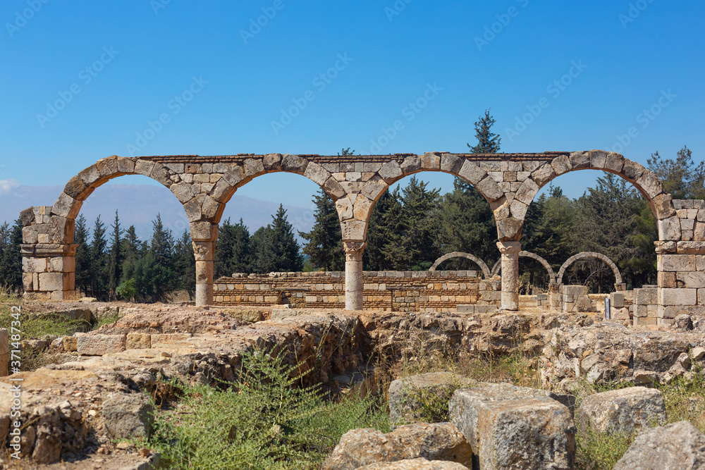 Ancient ruins in the city of Anjar, Lebanon. Stone Colonnade and columns against a bright blue sky