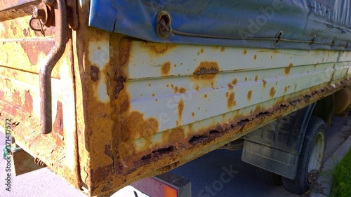 Sheet metal corrosion of old truck body. Rusty surface, background and damaged texture from road salt and reagents. Protection car and Professional paint work concept. Messy dirty rust Cargo bed. 
