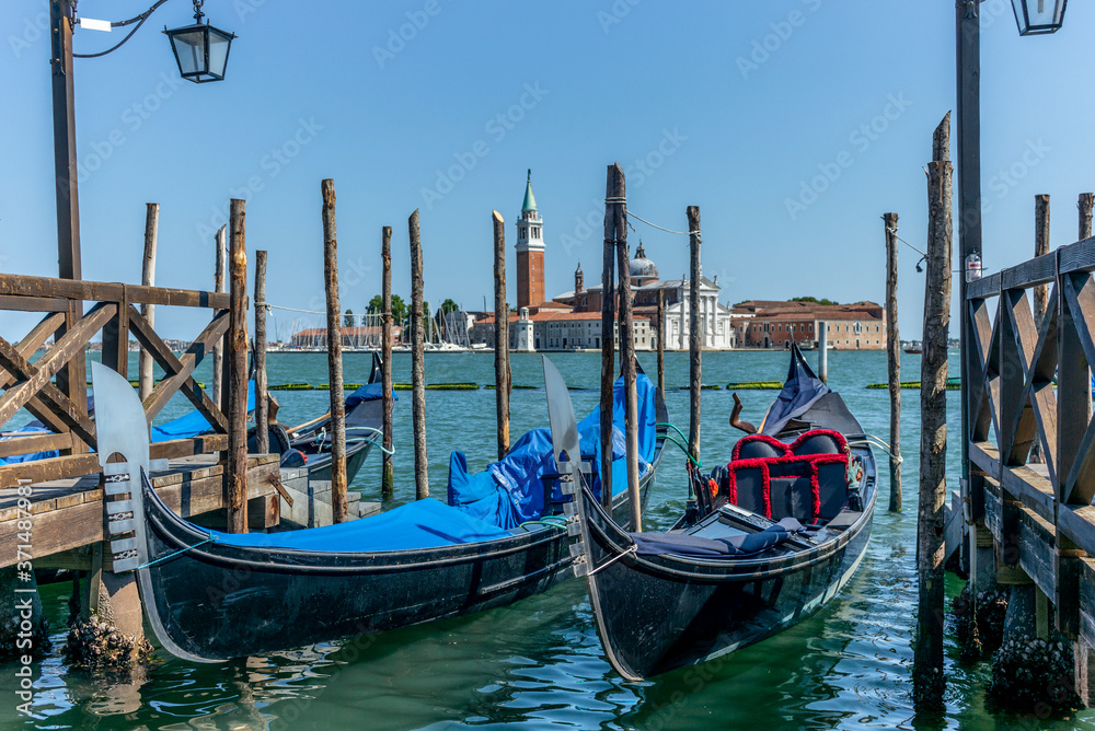 Gondolas in summer in Venice with the church of San Giorgio Maggiore