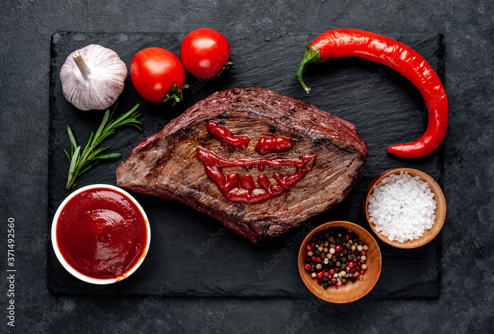 Grilled beef monster steak with spices for halloween on stone background