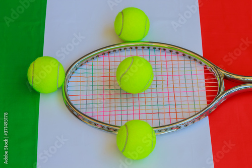 italian tennis / Tennis racket in metal with colored ropes and yellow tennis balls with the italian flag in the background © cannes106