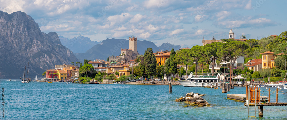 Malcesine - The panorama of promenade over the Lago di Garda lake with the town and castle in the background.