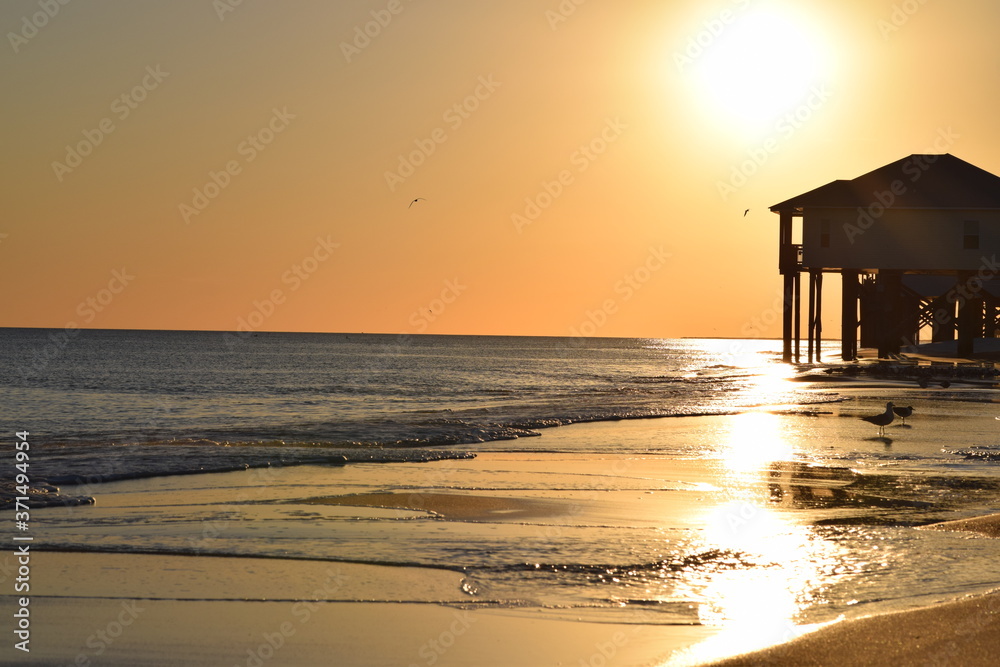 Beach house sunset over ocean