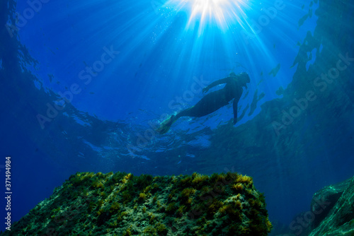 a scuba diver swims above a Mediterranean seabed