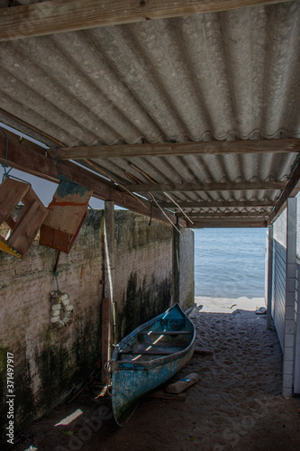 A boat in the foreground in a garage and in the background the sea