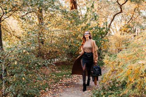 beautiful girl in a coat, black skirt and jacket autumn walks in glasses © Олег Блохин