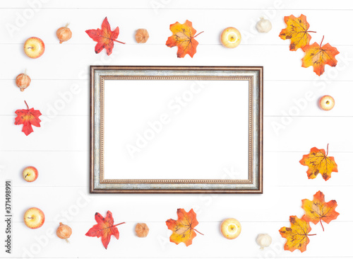 Vintage frame and bright autumn leaves on a white wooden background