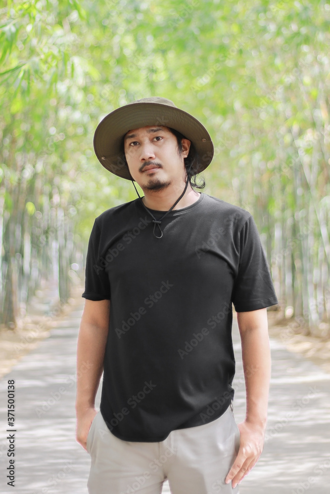 portrait of asian man wearing safari hat and black t-shirt.