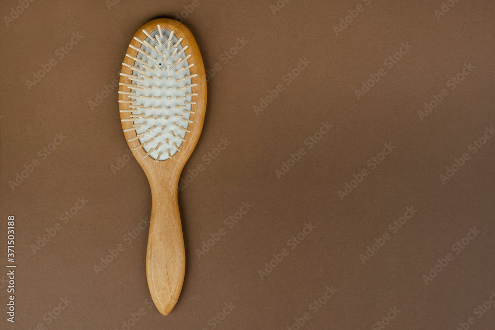 Massage comb with wooden handle on table. Device for combing hair. Eco beauty concept. Massage comb with wooden handle on table. Device for combing hair. Eco beauty concept.