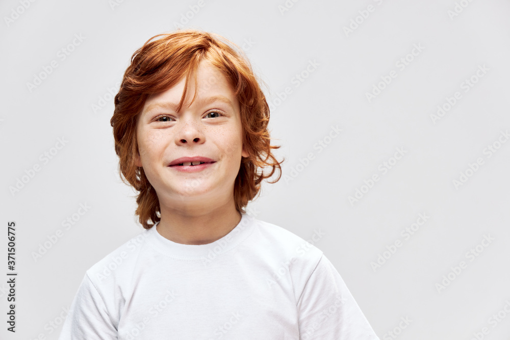 Cheerful boy cropped view white t-shirt smile studio gray background Cheerful boy cropped view white t-shirt smile studio gray background